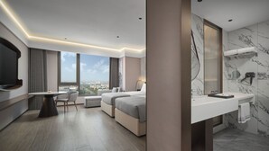 Une chambre d’hôtel moderne dotée d’un grand lit, d’un bureau, d’une chaise, d’une salle de bain avec un lavabo en marbre et offrant une vue sur la ville.