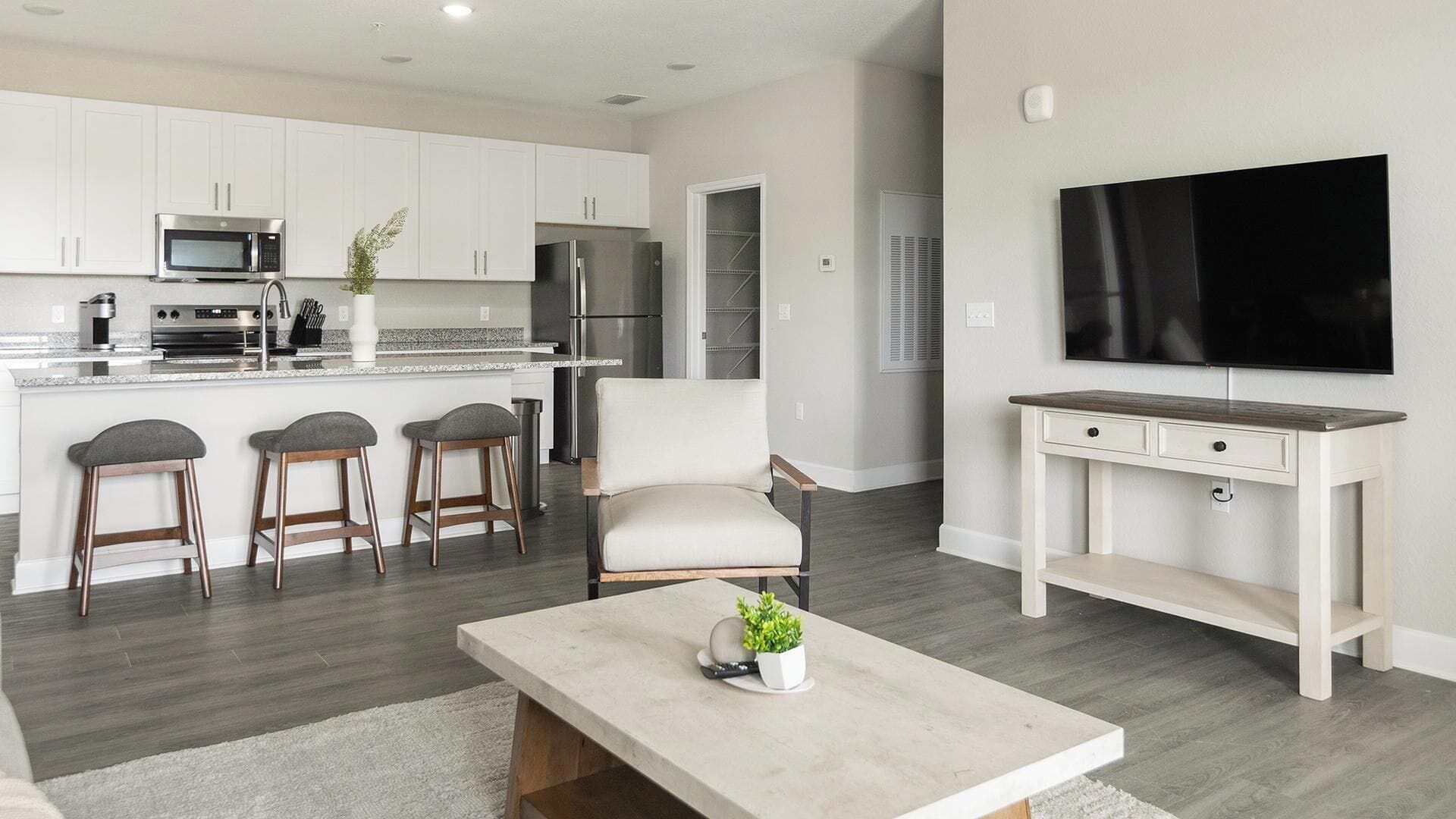 A modern kitchen with white cabinets, a built-in microwave, and a stainless steel refrigerator.