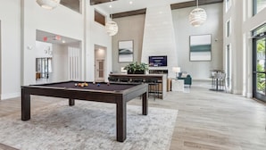 A pool table, bar area, seating, and large windows in a modern indoor space. - Landing | Spectacular 1BD, Gym, Clubhouse (Jacksonville)