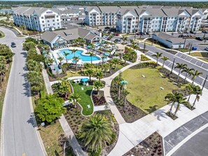 A resort with a swimming pool, multiple buildings, and a parking area. - Landing | Beautiful 1BD, Clubhouse, Gym (Laurel)