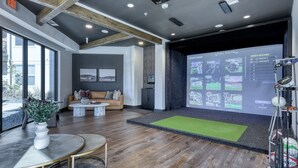 A modern interior with a large screen displaying games, a sofa, and a coffee table. - Landing | Incredible 1BD, Yoga Studio (San Antonio)