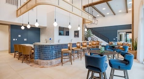 A modern hotel lobby with a bar area, seating, and a staircase. - Landing | Stunning 2BD, Yoga Studio (San Antonio)