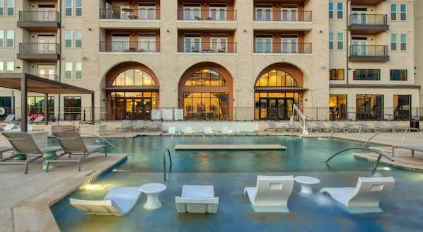 A hotel with a swimming pool, lounge chairs, and a covered patio area. - Landing | Stunning 2BD, Yoga Studio (San Antonio)