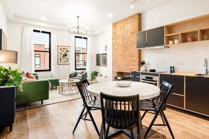 A modern apartment with a dining area, kitchen, and living space. - 7BR Retreat, Walkers Paradise Near Washington Park (Cincinnati)