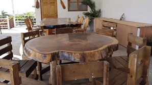 Une table à manger en bois, des chaises, un banc en bois et une porte en bois.