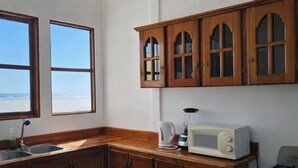 Une cuisine avec des meubles de rangement en bois, un four à micro-ondes, un mixeur et une cuisinière.