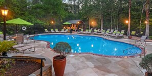 A swimming pool with lounge chairs and a small building in the background. - Landing | Amazing 2BD, Pool, Gym (Biloxi)