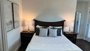 A hotel room with a large bed, two bedside tables, and a mirror on one wall. - CWB Retreats at Bayside View 4 - 1 Studio (Clearwater)