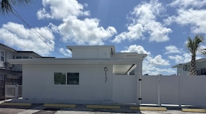 A white building with the number 617, a gated entrance, and a clear sky with clouds. - CWB Retreats at Bayside View 4 - 1 Studio (Clearwater)