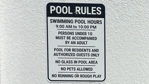 Ein Schild mit Poolregeln und einem Rettungsring.