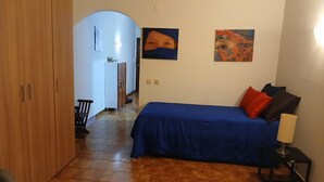 Une chambre à coucher avec un lit, une armoire, un bureau et une chaise.