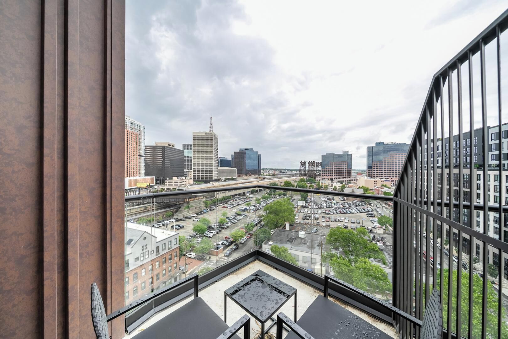 Un immeuble de grande hauteur offrant une vue sur un parking et sur le paysage urbain.
