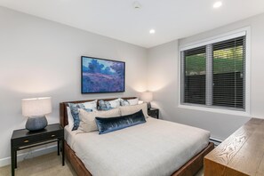 A bedroom with a bed, bedside tables, a lamp, a painting, and a window with blinds. - Sun Vail 11b, 3BD Condo (Vail)