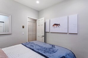 A bedroom with a bed, a door, and three wall-mounted artworks. - Sun Vail 11b, 3BD Condo (Vail)