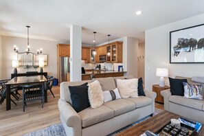 A modern living room with a sofa, coffee table, and dining area. - Sun Vail 11b, 3BD Condo (Vail)