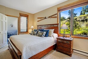 A bedroom with a bed, dresser, window with a view, and a door. - Sun Vail 22b, 2BD Condo With Vail Mountain Views (Vail)