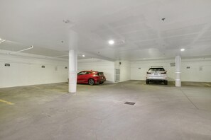 A parking garage with two cars parked, white pillars, and a clean, empty floor. - Tyrolean 5, 3BD Condo in Vail Village (Vail)