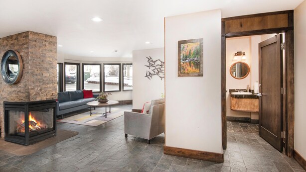 A modern living room with a fireplace, a sofa, a coffee table, and a painting on the wall. - Westwind 407 3BD 2BA Gold Condo in Vail Lionshead Village (Vail)