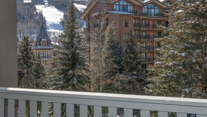 A multi-story hotel with balconies, a clock tower, and a snowy mountain backdrop. - Westwind 407 3BD 2BA Gold Condo in Vail Lionshead Village (Vail)