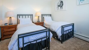 A bedroom with two beds, bedside tables, lamps, and a wall-mounted artwork. - Westwind 407 3BD 2BA Gold Condo in Vail Lionshead Village (Vail)
