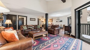 A spacious living room with leather sofas, a coffee table, and a colorful rug. - Westwind 407 3BD 2BA Gold Condo in Vail Lionshead Village (Vail)