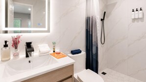 A modern bathroom with a white sink, mirror, shower, and toilet. - Modern Studio Private Parking Near Beach (Hollywood)