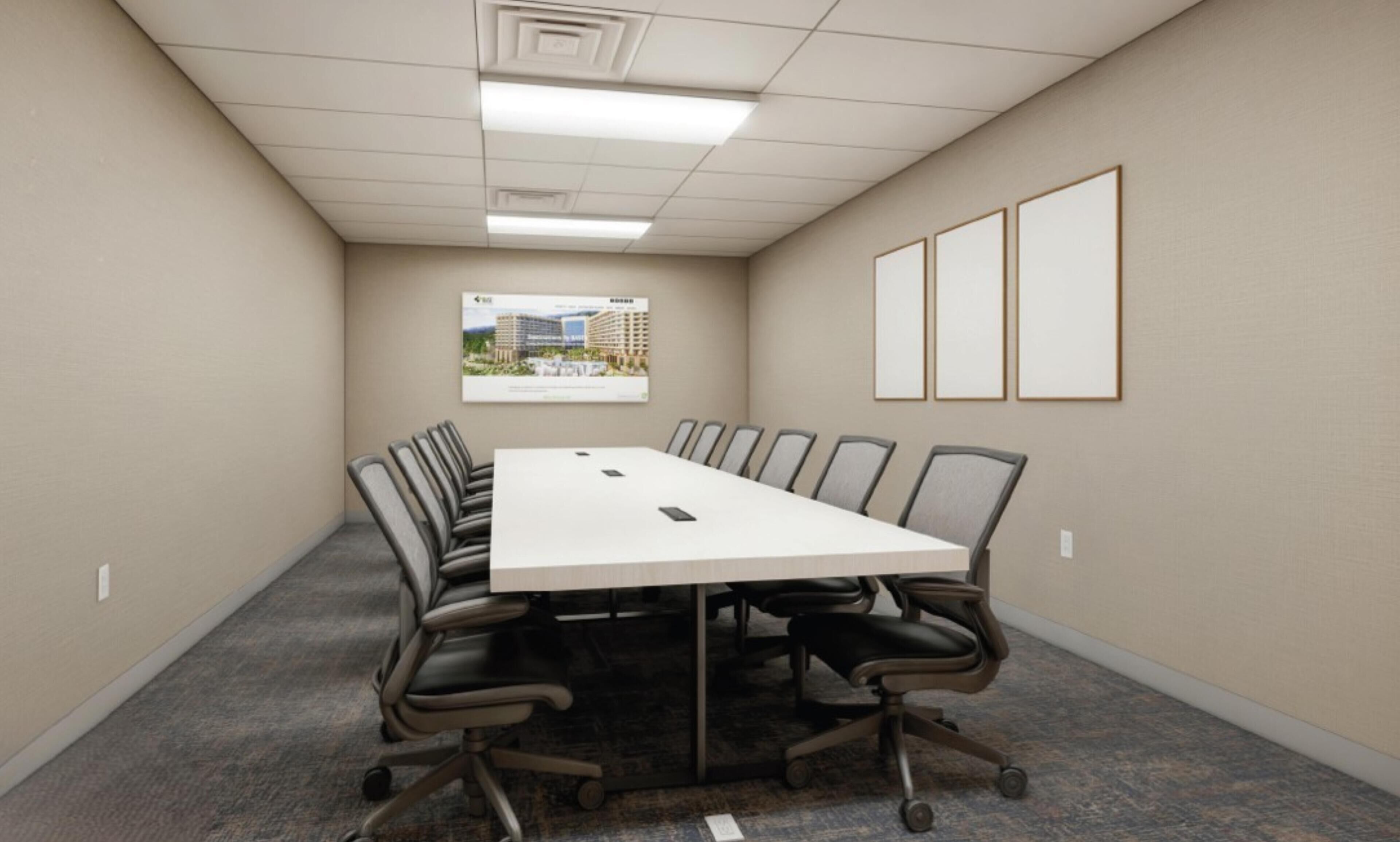 A conference room with a long table, chairs, a carpeted floor, a framed picture on the wall, and a ceiling with recessed lighting.