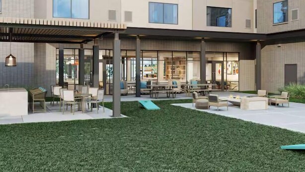 A modern building with a covered outdoor seating area, a grassy courtyard, and large windows. - Homewood Suites By Hilton Shreveport South (Shreveport)