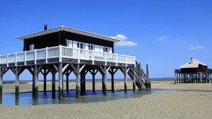 Une jetée en bois avec une maison et une petite construction sur pilotis.