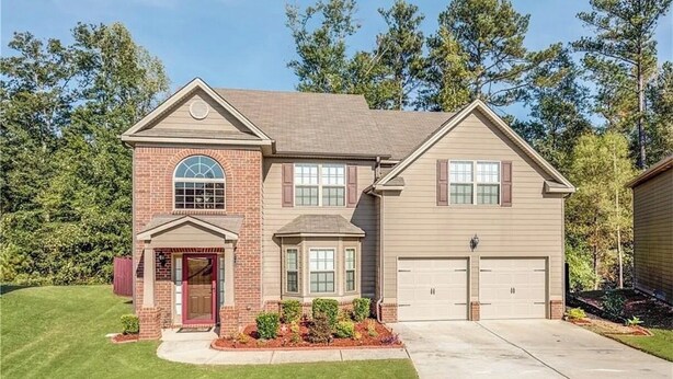 A two-story house with a brick entrance, a bay window, and a garage. - Welcome to Mr. T's Palace!
Stay big. Relax easy. 
Your Home away from Home. (Jonesboro)