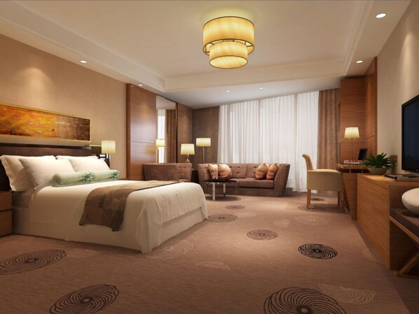A hotel room with a large bed, a sofa, a desk, and a television.