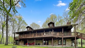A two-story lodge with a stone facade, wooden balconies, and a covered porch area.