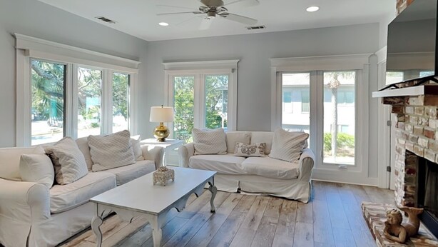 A spacious living room with a white sofa set, a coffee table, and a fireplace. - Tybee Straits 17 (Tybee Island)