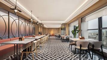 A modern restaurant with high tables, chairs, and a patterned floor.