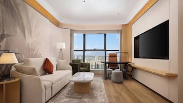A modern living room with a sofa, armchairs, a coffee table, and a TV.