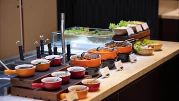 Un buffet proposant divers plats servis dans des bols et des récipients, disposés sur un comptoir.