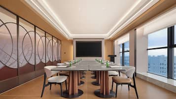A conference room with a long table, chairs, a projector screen, and large windows.