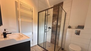 A modern bathroom with a glass shower enclosure, a white sink, and a toilet. - Haus an der Panke, room with bathroom (Panketal)