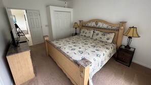 A bedroom with a wooden bed, two bedside lamps, a ceiling fan, and a desk with a chair. - Lakeview Villa (Davenport)