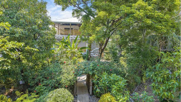 A lush garden with a wooden bridge leading to a building with a balcony. - Jungle Studio -Steps to Beach-Wi Fi -AC-Work-Surf (Santa Teresa)