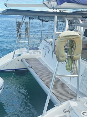 Le pont d’un bateau, avec un gilet de sauvetage, un volant et une rambarde en forme de filet.