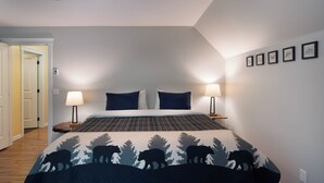 Ein Schlafzimmer mit einem Bett, zwei Nachttischlampen, einem Deckenventilator und einer Tür zu einem anderen Raum.