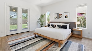 A bedroom with a bed, a nightstand, a ceiling fan, and a window with a view of greenery. - Greyhawk Golf Escape w/ 5-Bedrooms, Heated Pool, Spa & Putting Green (Scottsdale)