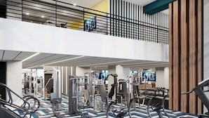 A gym with various exercise equipment, a mezzanine level, and a patterned floor. - Cozy modern Hollywood Getaway (Beverly Hills)