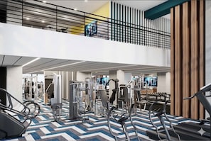 Un gimnasio con varios equipos de ejercicio, un entrepiso y un suelo con diseño.