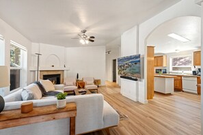 Ein geräumiges Wohnzimmer mit Kamin, Essbereich und Küche mit Holzausstattung.