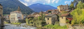 Un pueblo histórico con edificios de piedra, una iglesia y un río.