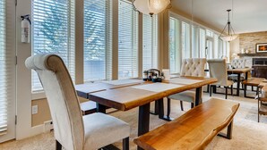 A dining area with a wooden table, chairs, and a bench. - Sun Vail 21b, 3BD Condo With Vail Mountain Views (Vail)