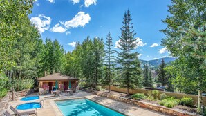 A pool area with lounge chairs, a small gazebo, and a view of mountains. - Sun Vail 21b, 3BD Condo With Vail Mountain Views (Vail)