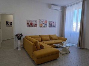 Appartement, balcon, vue partielle sur la mer | Coin séjour | TV connectée de 65 pouces avec chaînes par satellite